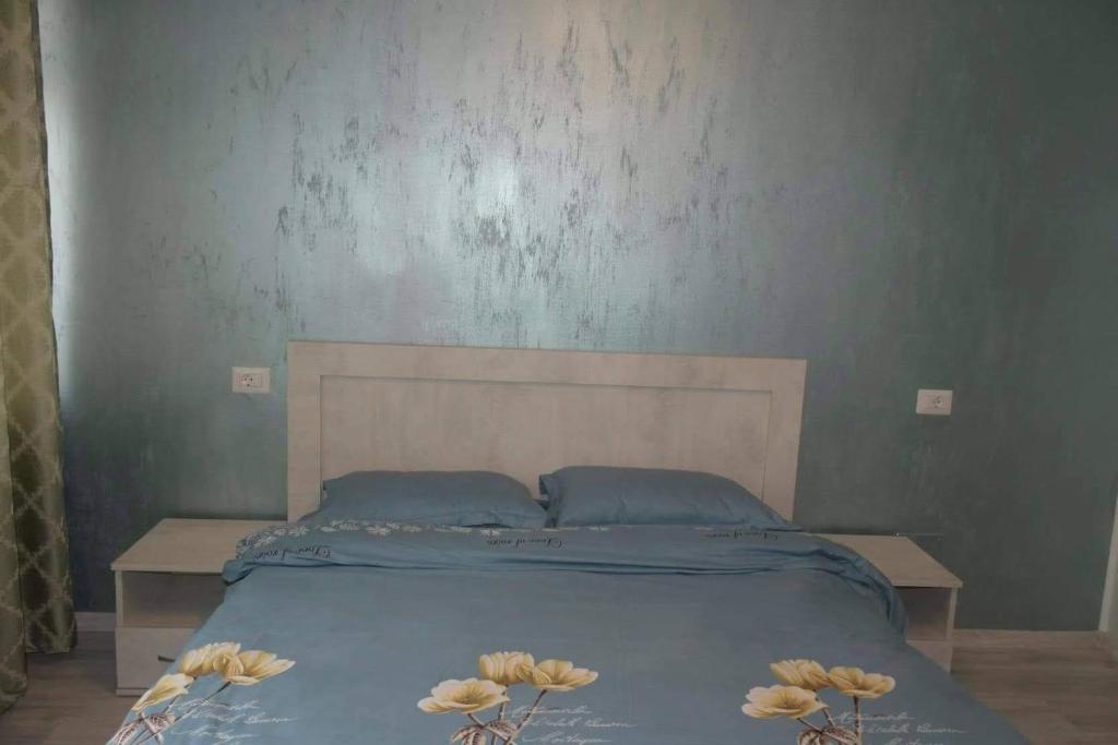 皮亚特拉-尼亚姆茨Pensiunea Red Rock的一张带蓝色床单的床和三朵花