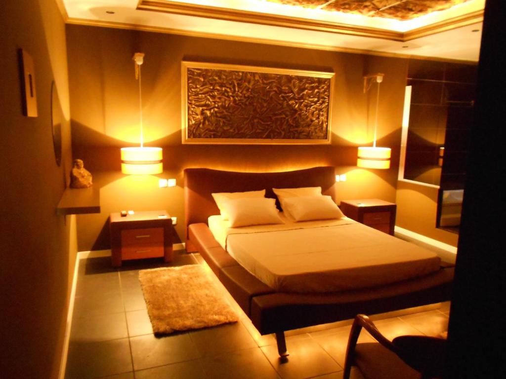 阿泽陶圣贡萨洛 - 阿罗加曼托酒店的一间带一张床和两盏灯的小卧室