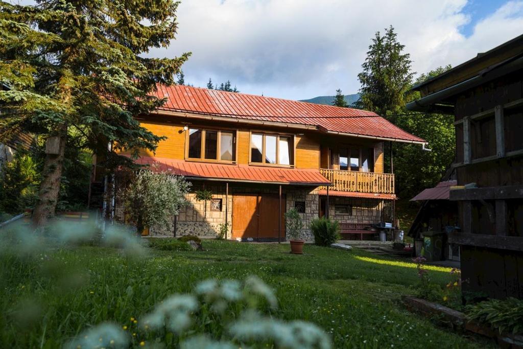 日利纳Chalupa v Štefanovej的一座红色屋顶的房子和一个院子