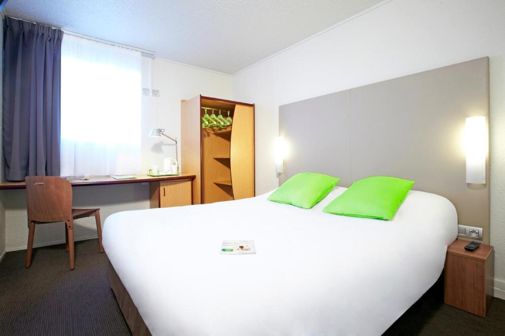 达迪利里昂达蒂利波特里昂钟楼酒店的酒店客房配有一张带绿色枕头的大型白色床。