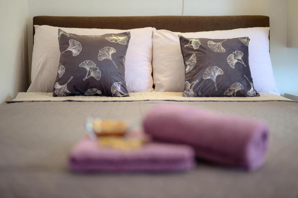 波达卡Studio Apartmani M的床上有枕头,上面有粉红色的物品