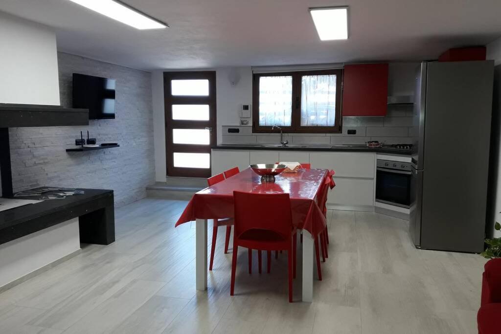托尔托利Incantos Charme B&B & Apartment的一间厨房,里面配有红色的桌子和红色的椅子