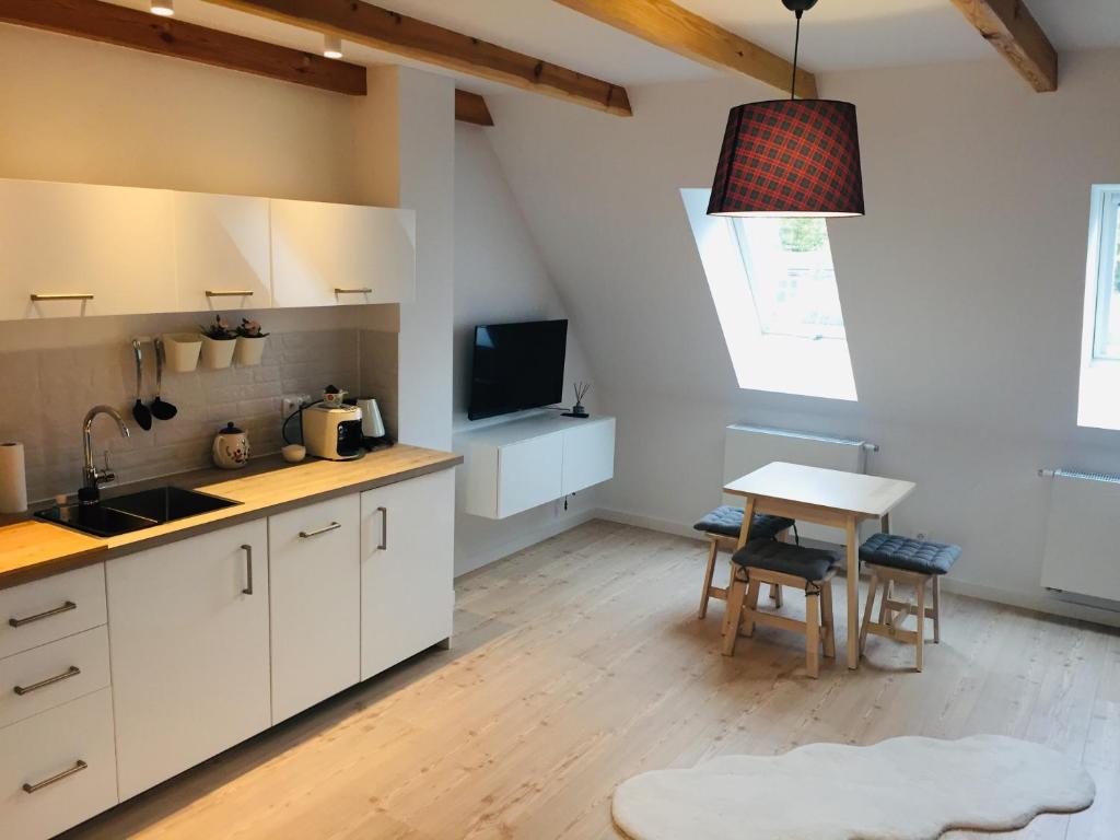 奥普尔Niezapominajek的厨房配有白色橱柜和桌子
