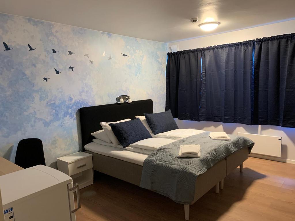 HusnesHusnes Sentrum Hotell的卧室配有一张墙上鸟床