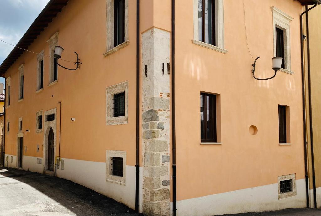 拉奎拉Il Sogno di Hypnos的一座带窗户和小巷的橙色建筑