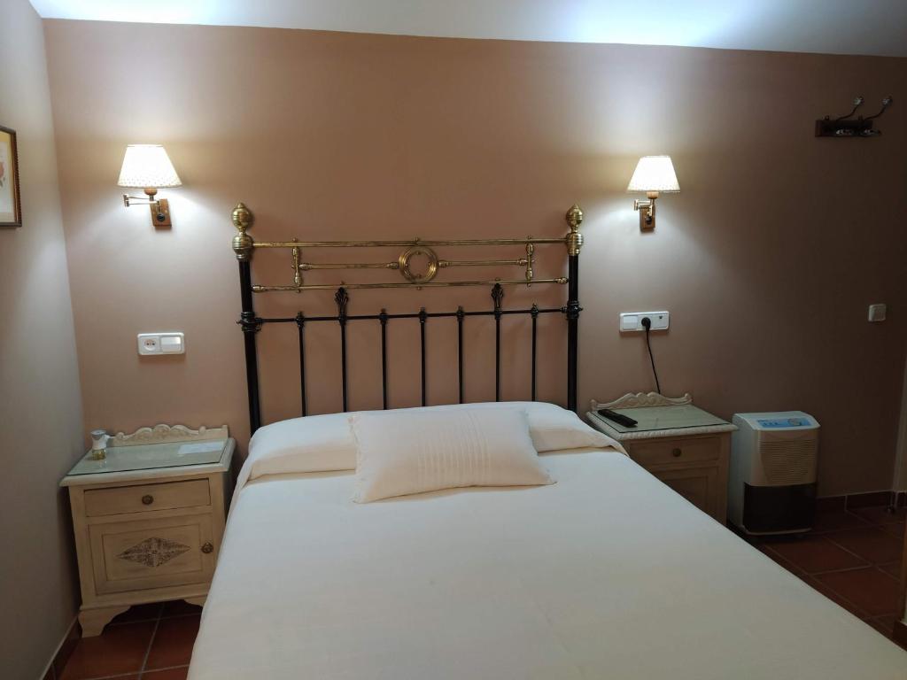 阿里纳斯·德·卡伯瑞勒斯Apartahotel Montecaoru的一间卧室配有一张带2个床头柜的大型白色床