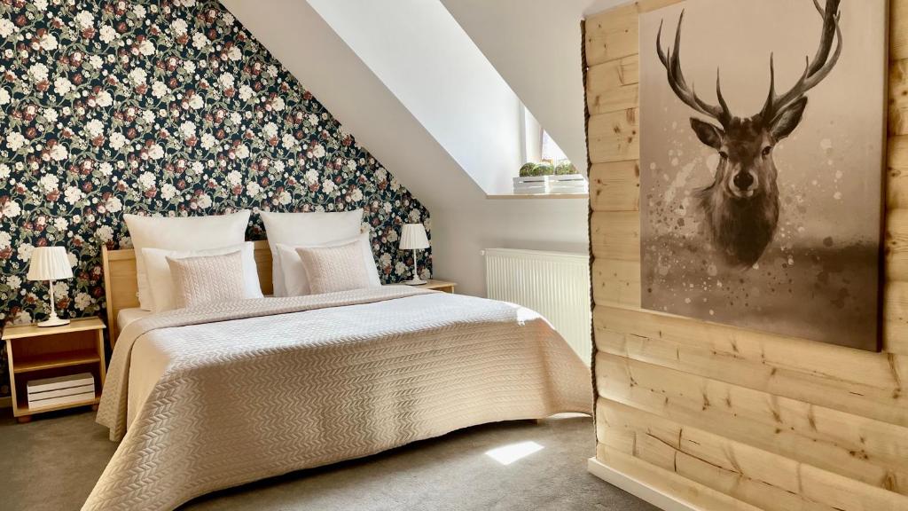 乌斯特龙Jaszowianka Best For You的卧室配有一张带鹿头的墙壁床。