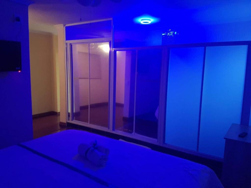 开普敦Khaya B&B的一间拥有蓝色灯光的卧室和一张带窗户的床