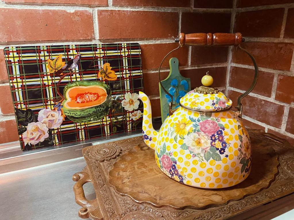 恩纳猫とピアノと星空のリゾートブティックコテージ - Starry Forest Cottage Okinawa -的坐在墙上桌子上的茶壶