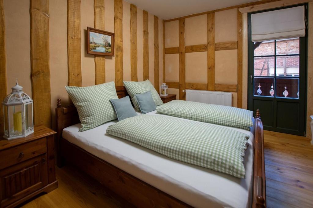 BollbergNaturhof-Papiermühle 3 Bett-Zimmer Immergrün的一间卧室配有带绿色和白色枕头的床