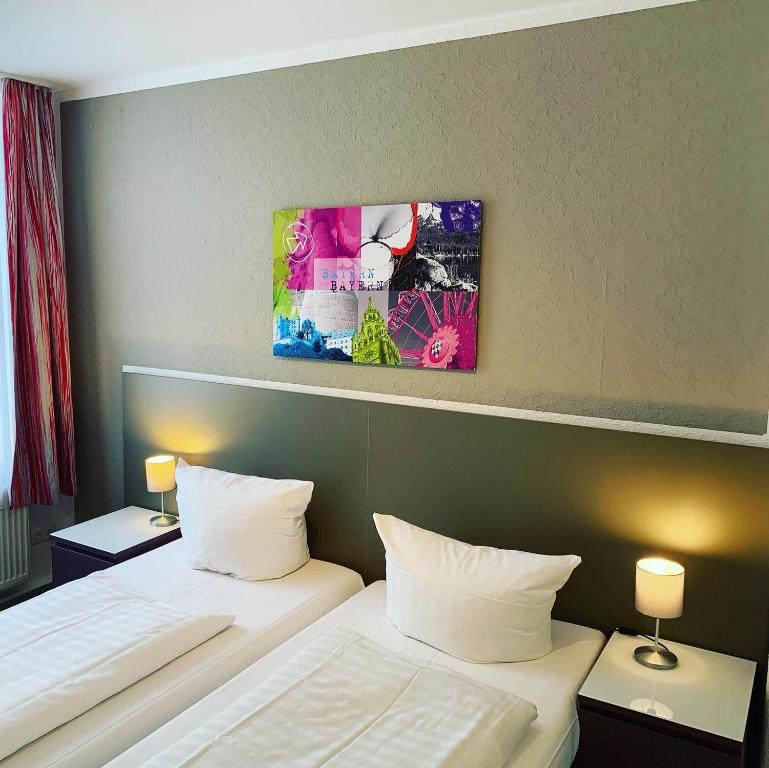 慕尼黑贝洛索诺膳食旅馆的酒店客房设有两张床,墙上挂有绘画作品