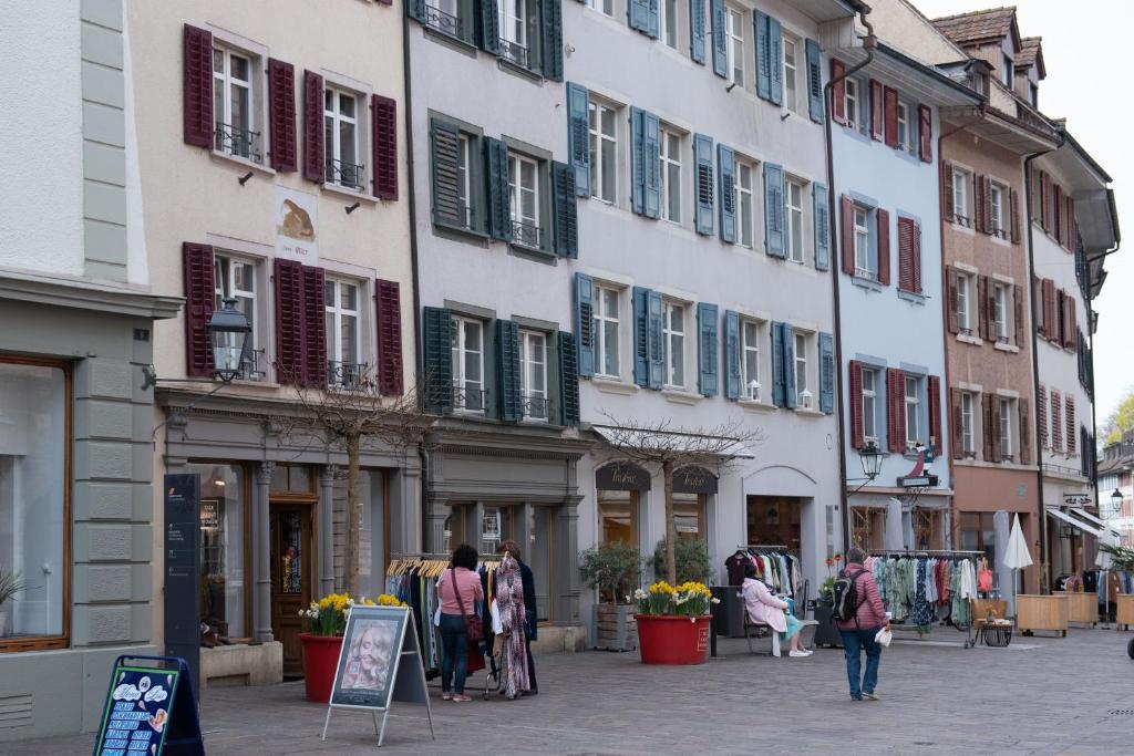 莱茵费尔登Unterkunft "Rathaus" Altstadt, Rheinfelden Schweiz的一群人沿着街道走着,街道上有许多建筑