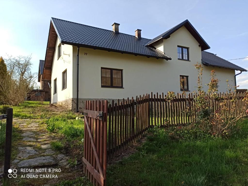 顺佩尔克Chalupa Hrabišín的白色的房子,设有木栅栏