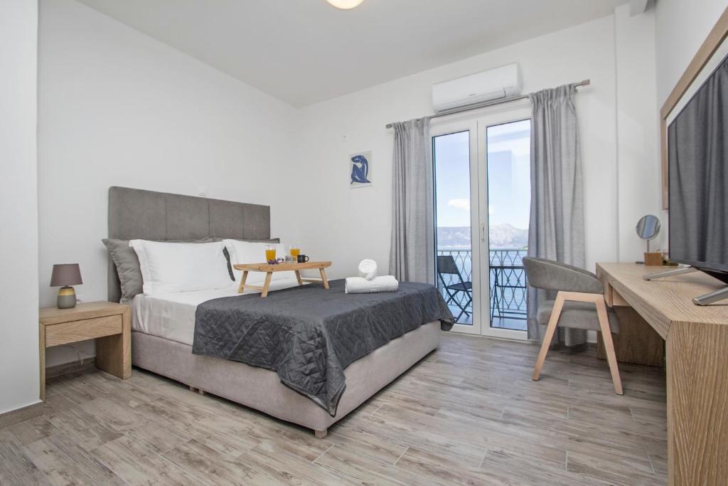 科孚镇Vidos Seaview Suite的一间卧室配有一张床、一张书桌和一台电视