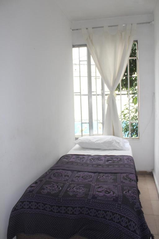 麦德林Hospedaje Primavera的卧室在窗户前配有一张床