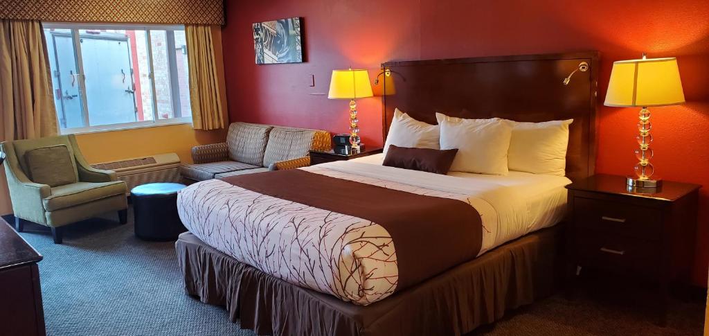 阿伯丁Olympic Inn & Suites的酒店客房带一张大床和一把椅子