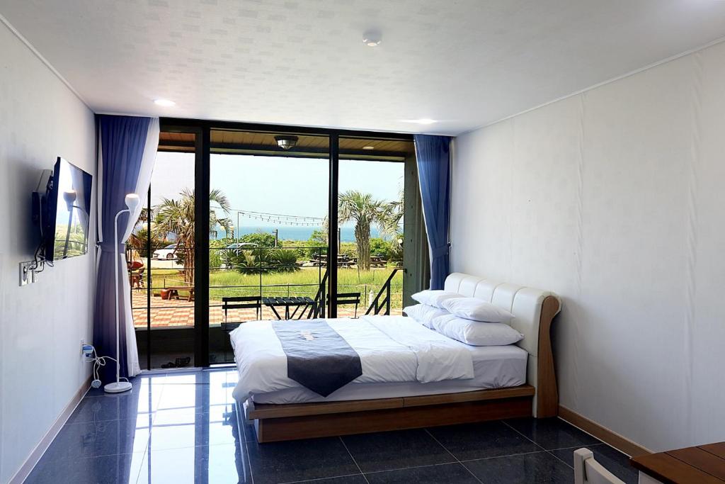西归浦市Ĵ劳姆度假村的一间卧室设有一张床和一个大窗户