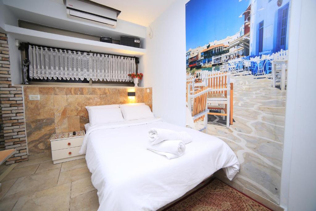 哈德拉Ahuzat Shaul - Studio的一间配备有白色床的卧室,享有城市美景。