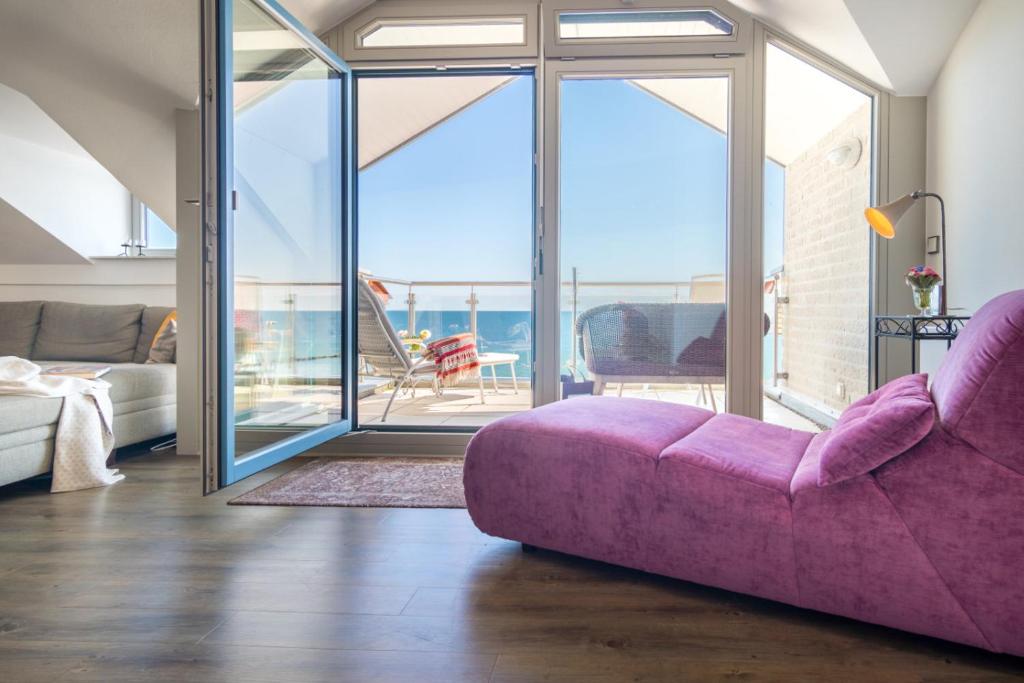 费马恩Turm-Appartement Strandburg的一间带紫色沙发的客厅和一个阳台