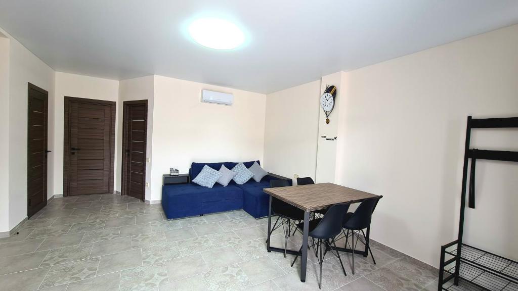 卡罗利诺-布加兹BUGAZ GOLD апартаменти біля моря的客厅配有蓝色的沙发和桌子