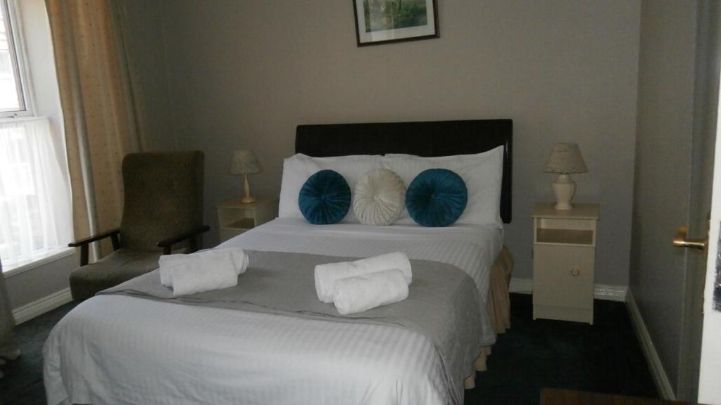 斯奇博瑞恩Ilenroy House的酒店客房配有一张带蓝色枕头的大床