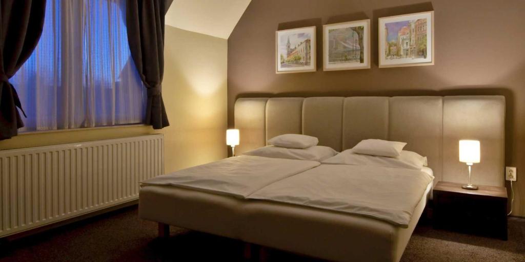 布达厄尔什Varga-ház panzió的一间卧室配有一张带两盏灯的床和一扇窗户。