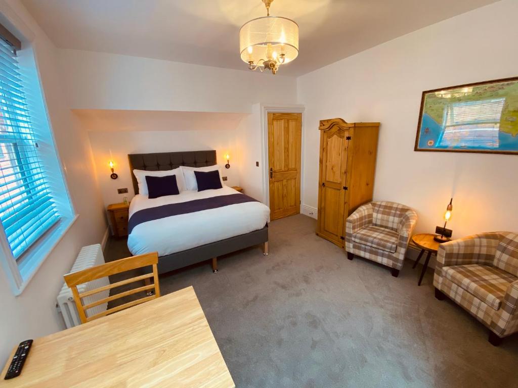 韦茅斯Self Contained Guest suite 2 - Weymouth的一间卧室配有一张床、一把椅子和一张桌子