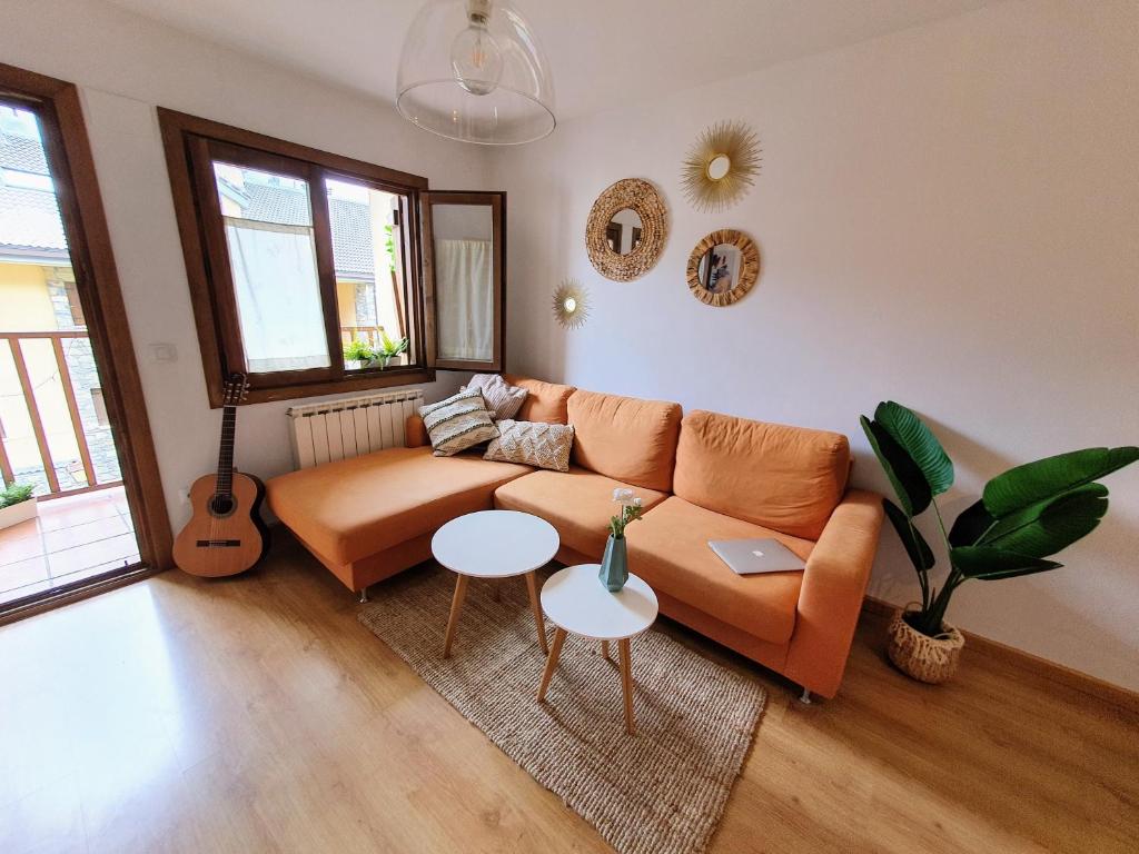比利亚努阿Apartamento de montaña y ESQUÍ en el Pirineo Aragonés, Villanúa - WIFI的带沙发和吉他的客厅