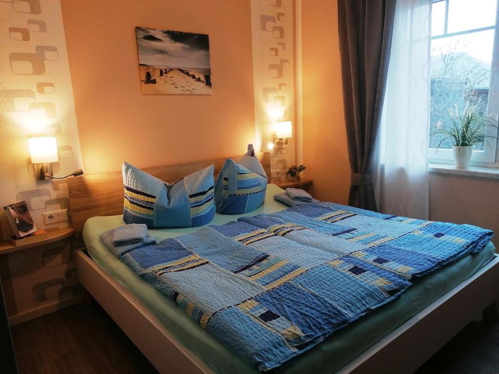因塞尔波埃尔Poeler Ostseeidyll的一间卧室配有一张带蓝色毯子和枕头的床。