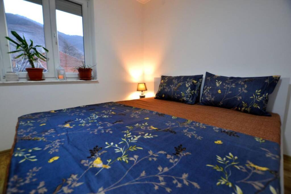 MokrievoView Apartments Belasica的一间卧室配有一张带蓝色毯子和鲜花的床
