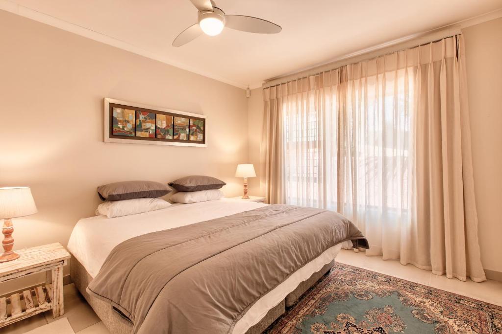 赫罗德斯湾Perlemoen Retreat的一间卧室设有一张大床和一个窗户。