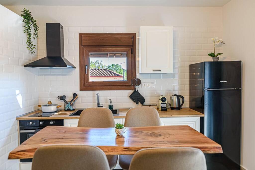 阿尔加拉斯蒂Melina's cosy appartment的厨房配有木桌和黑冰箱。