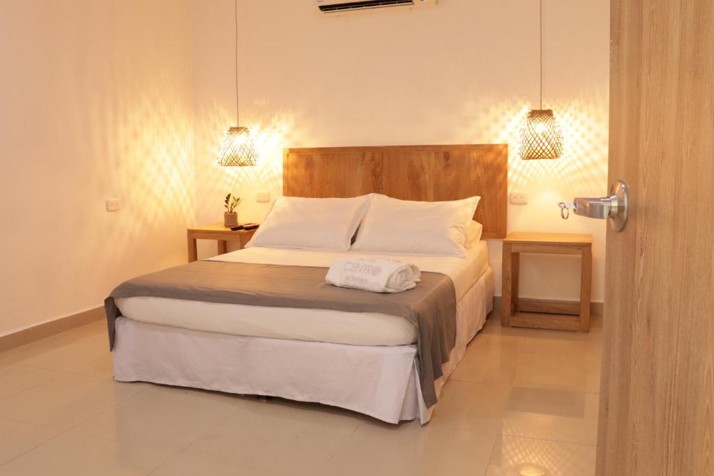 蒙特里亚Hotel Centro Monteria的一间卧室配有带2个床头柜和2盏灯的床