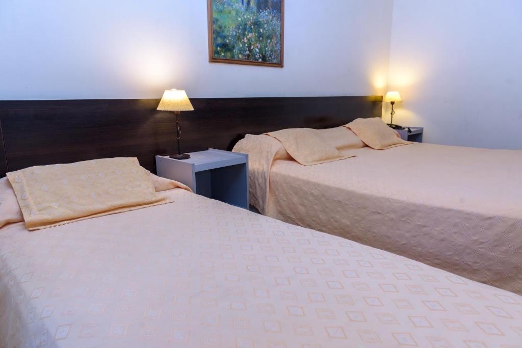 圣胡安Hotel Cerro Blanco的配有2盏灯的酒店客房的2张床
