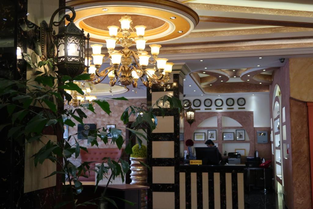 蒙罗维亚Boulevard Palace Hotel的一间有吊灯的餐厅和一个坐在桌子上的人