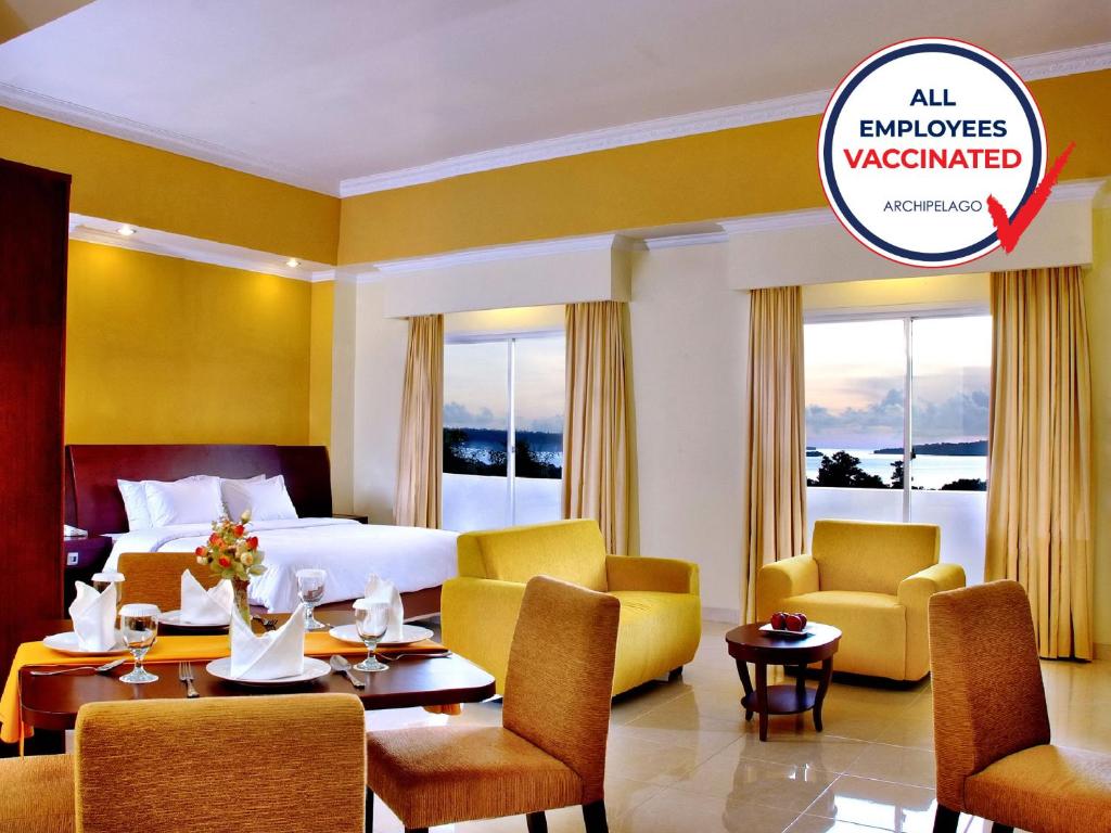 曼诺瓦里ASTON Niu Manokwari Hotel & Conference Center的配有床、椅子和桌子的酒店客房