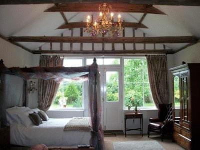 西洛尔核桃乡村官邸酒店的一间卧室设有一张天蓬床和大窗户