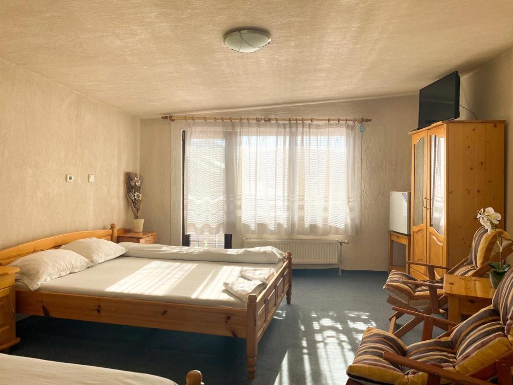 多斯帕特Къща за гости с механа БАДЖО的一间卧室设有一张大床和一个窗户。