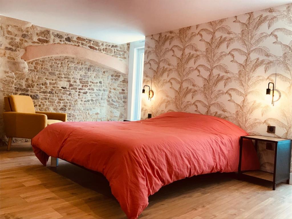 卡朗唐Le Salon de l'Isle的一间卧室设有红色的床和砖墙