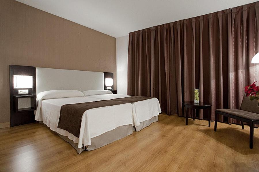 赫塔费卡洛斯三世旅馆的酒店客房带一张大床和一把椅子