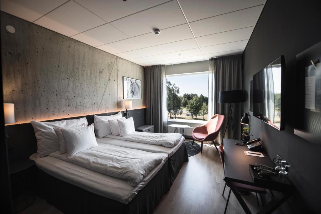 厄斯特松德Frösö Park Hotel的配有一张床和一张书桌的酒店客房