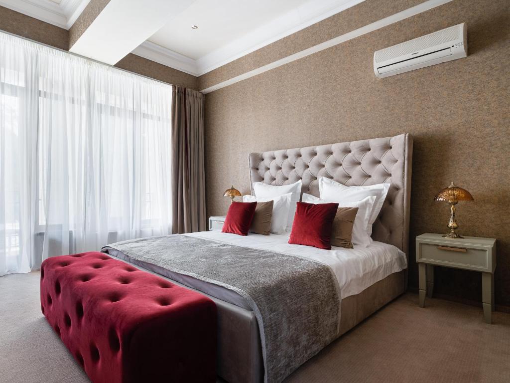 阿德勒Golden Dolphin的一间卧室配有一张带红色枕头的大床