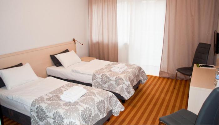 KleosinZdrojówka Noclegi的酒店客房设有两张床和窗户。
