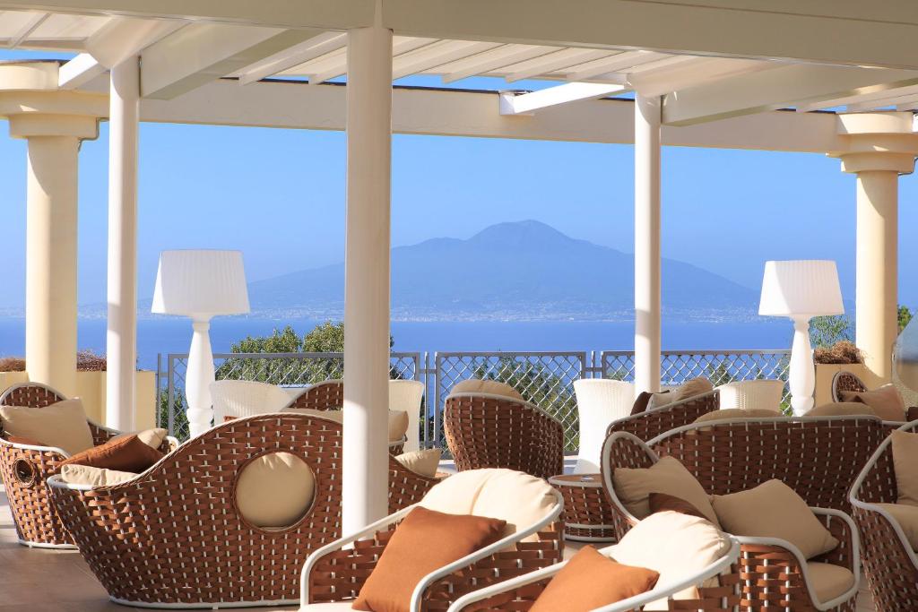 索伦托大西洋皇宫酒店的一个带椅子的门廊,享有海景