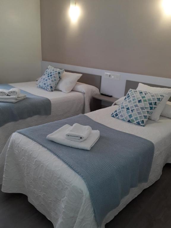 坎加斯-德奥尼斯Pension Principado的酒店客房,配有两张带毛巾的床