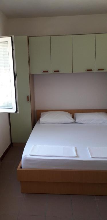德雷斯Apartments Andrijana的一间卧室配有一张带白色床单的床和一扇窗户。