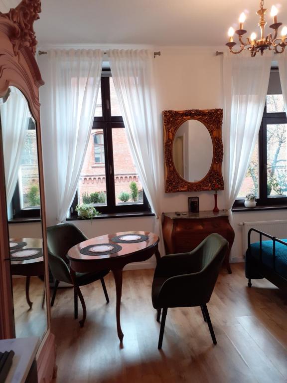 比得哥什Apartment lux gimnazjalna的客厅配有桌椅和镜子