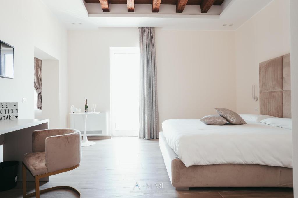 塔兰托A-mare Exclusive Rooms & Suites的卧室配有床、椅子和窗户。