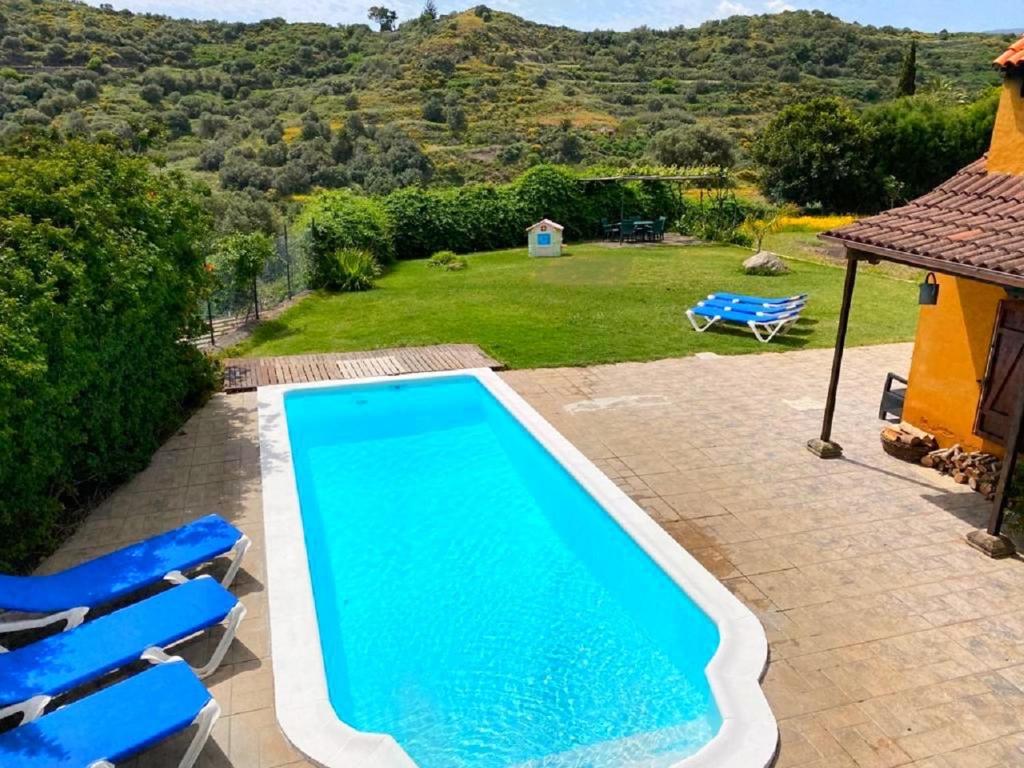 特罗尔Casa Rural CaChispita的一个带2把蓝色椅子的游泳池
