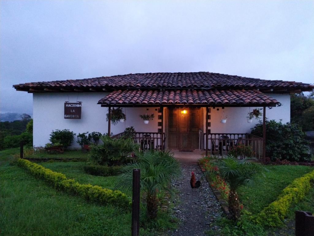 ChinchináHacienda Cafetera La Gaviota的院子内有门的小白色房子